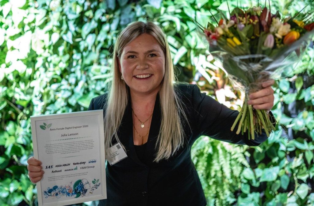 Julia Larsson, årets Female Digital Engineer, med blommor och diplom.