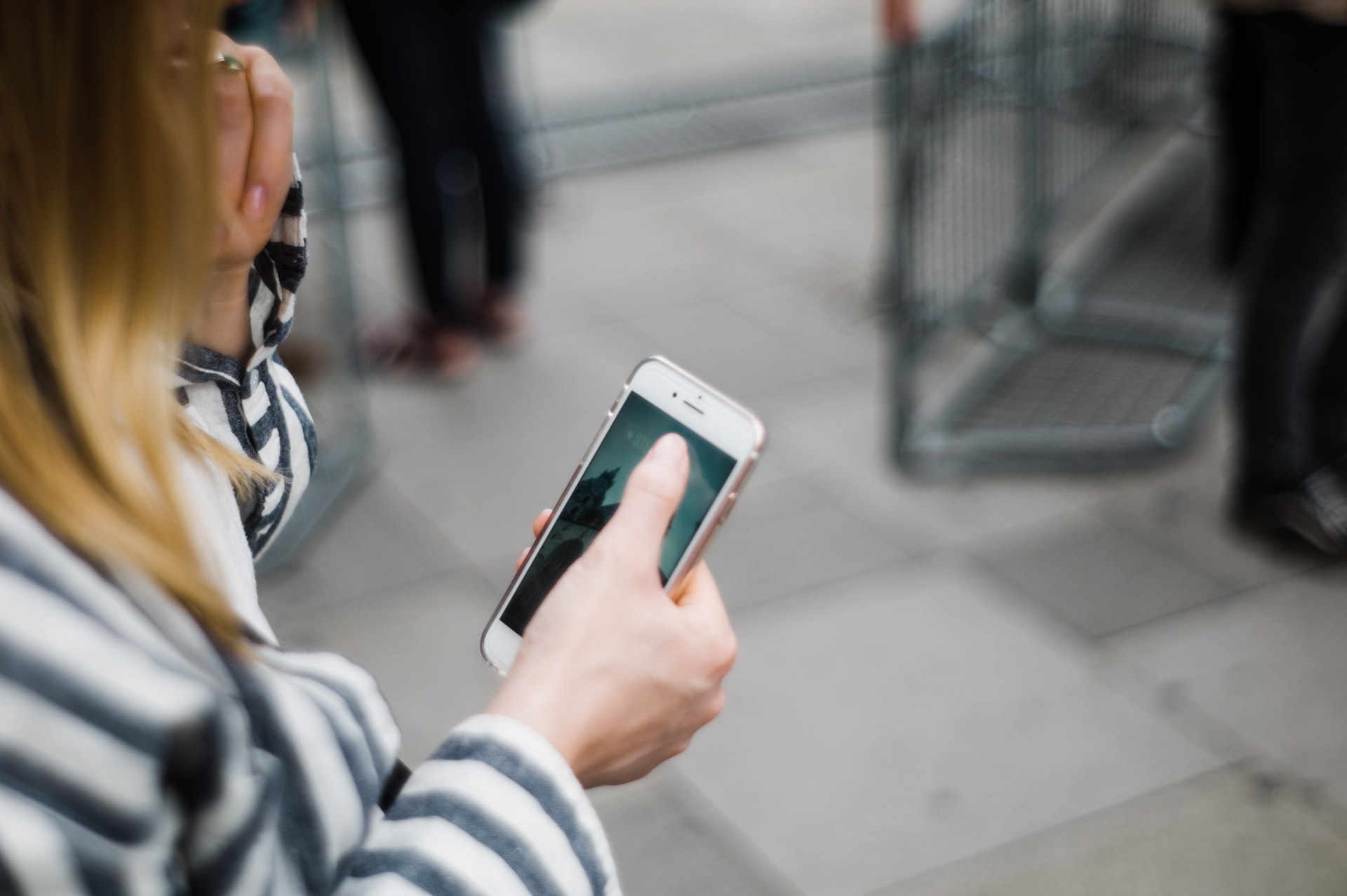 Bilden visar en kvinnas hand som håller i sin mobiltelefon.