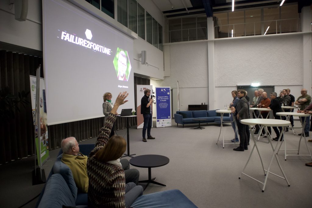Foto från Failure2Fortune som visar en deltagare som räcker upp sin hand för att delta i diskussionen